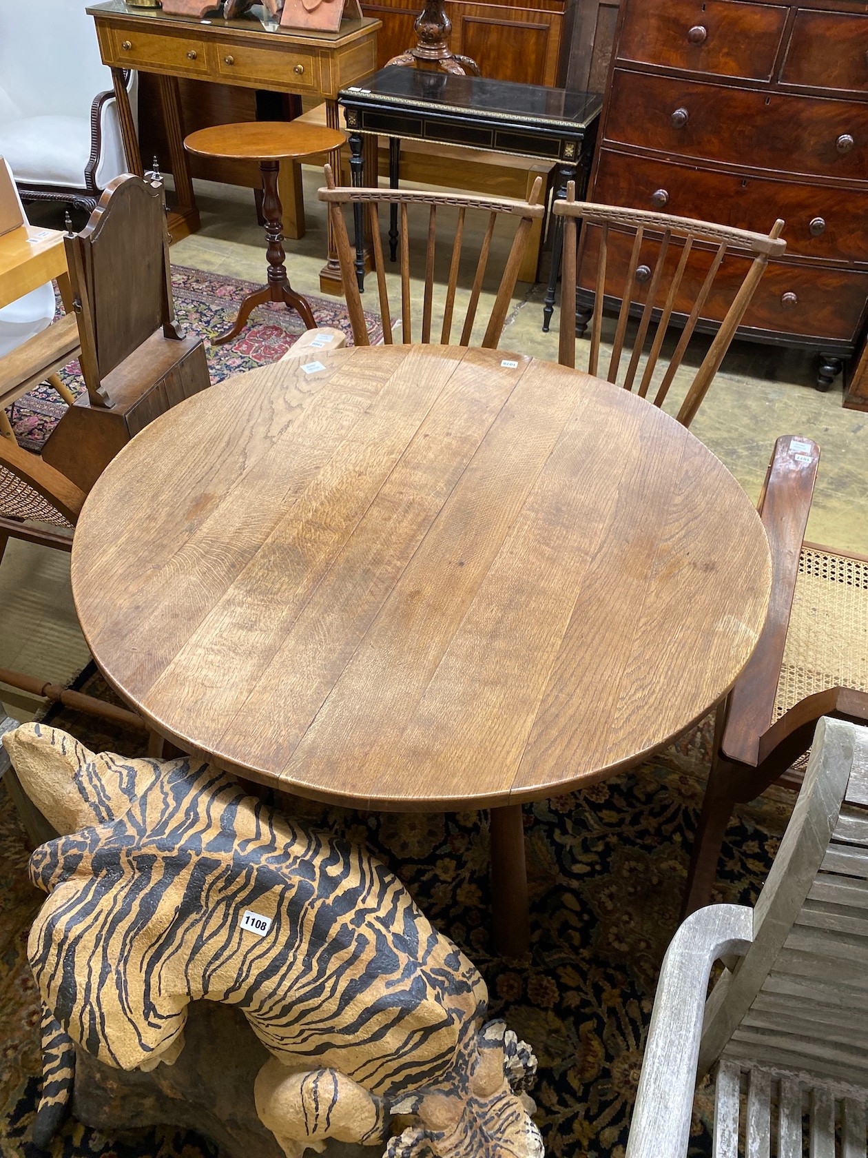 An Arts & Crafts style circular oak table, diameter 110cm, height 73cm and two chairs